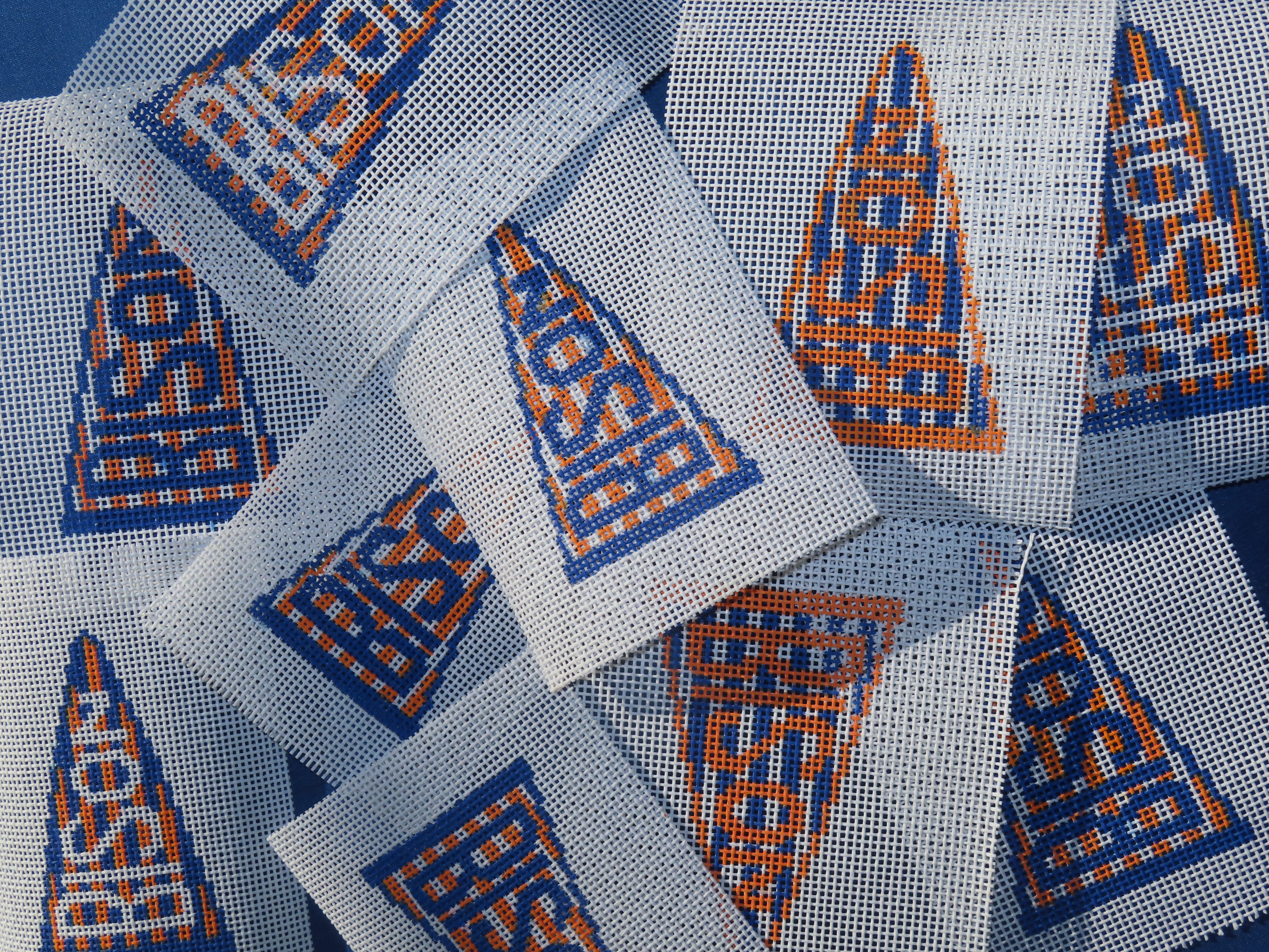 needle point canvases stacked on top of one another